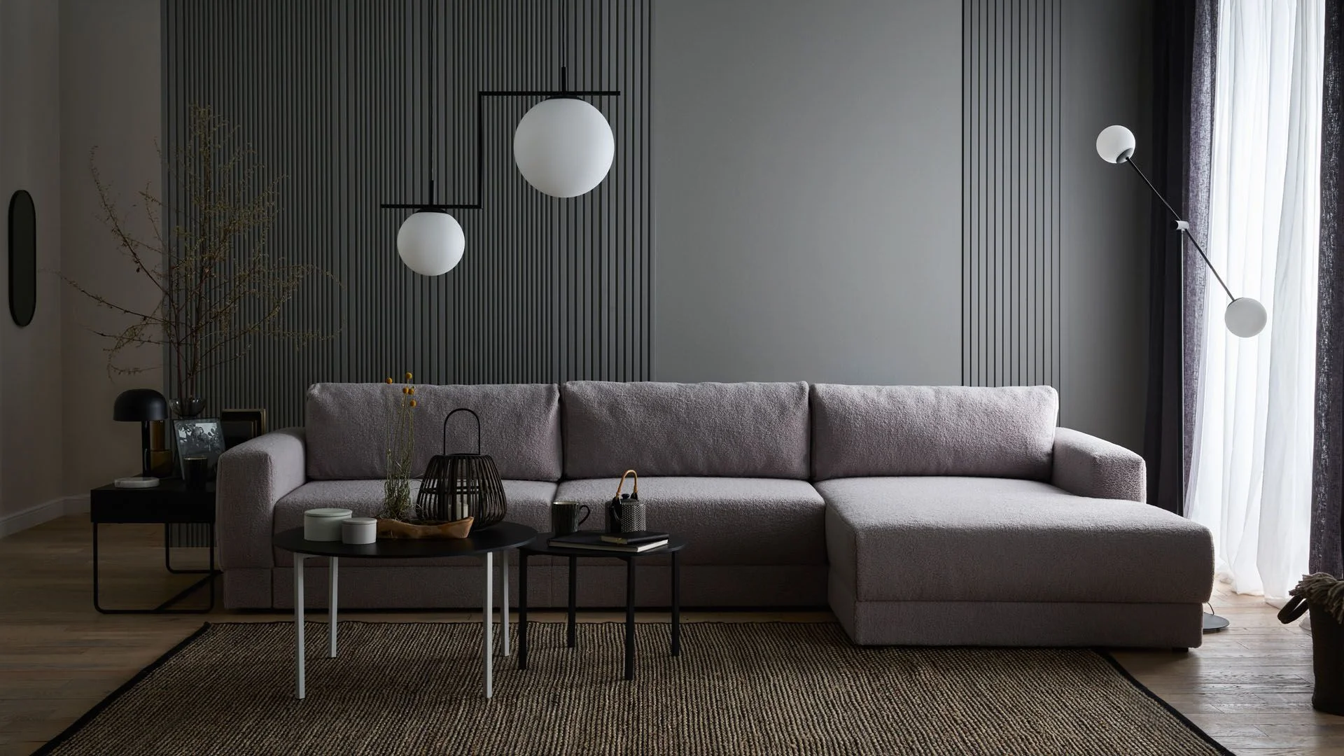 Elegancki salon w odcieniach szarości z grafitową ścianą lamelową i minimalistycznym oświetleniem.